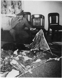 Ramey montrant les d&eacute;bris d'un ballon pour expliquer l'incident de Roswell aux journalistes