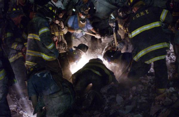 Des pompiers regardant par un trou du métal en fusion ? Non, regardant à la lumière d'une lampe. 