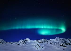 Une aurore bor&eacute;ale tournoyant &agrave; travers le ciel au-dessus de la cha&icirc;ne montagneuse sur le glacier Canwell (Alaska)